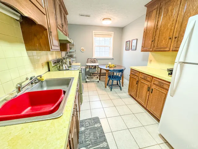 a view of a house with a large tree and a yard