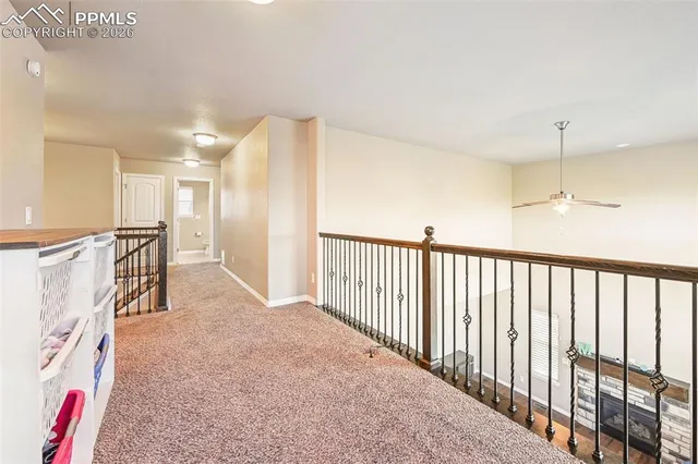 a view of a hallway with furniture and a chandelier