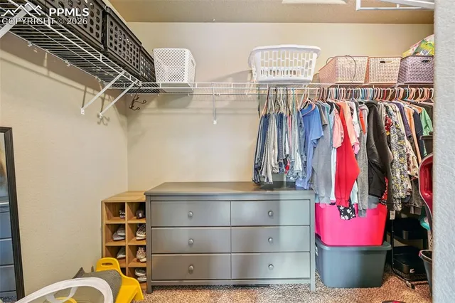 a view of walk in closet with clothes and shoes