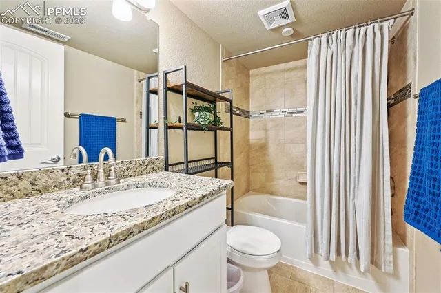 a bathroom with a granite countertop sink toilet mirror and bathtub