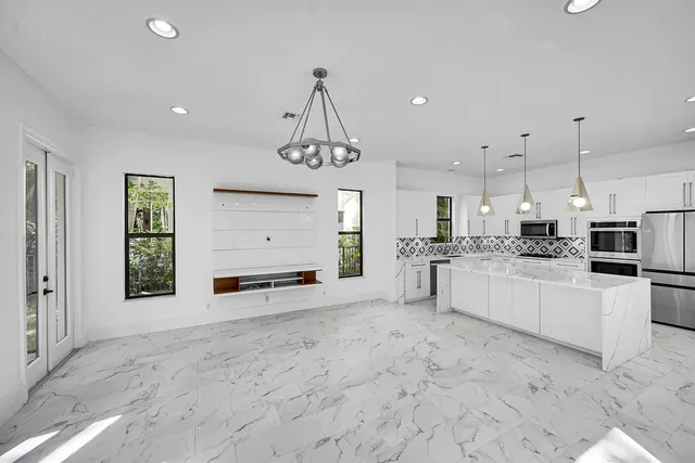 a kitchen with granite countertop white cabinets white appliances and a sink