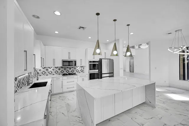 a large kitchen with a large counter top appliances and cabinets