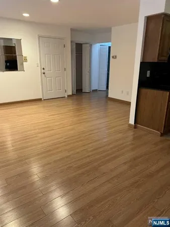 an empty room with wooden floor and cabinets