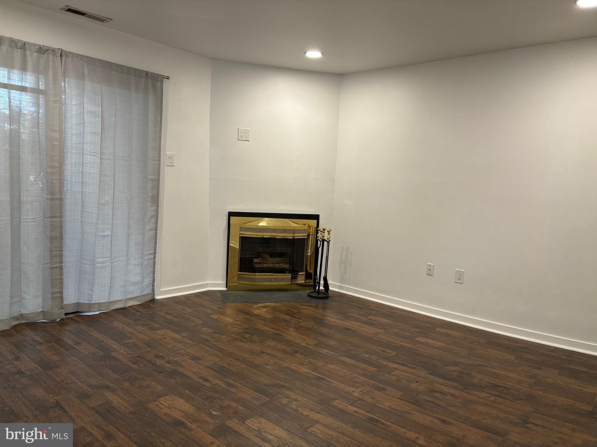 101 Gregorys Way Voorhees, NJ 08043 - Photo 11 of 16 a view of an empty room with wooden floor and a fireplace