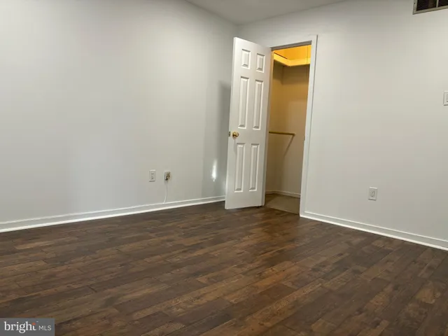 a view of empty room with wooden floor and cabinet