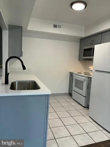 a kitchen with a sink cabinets and stainless steel appliances