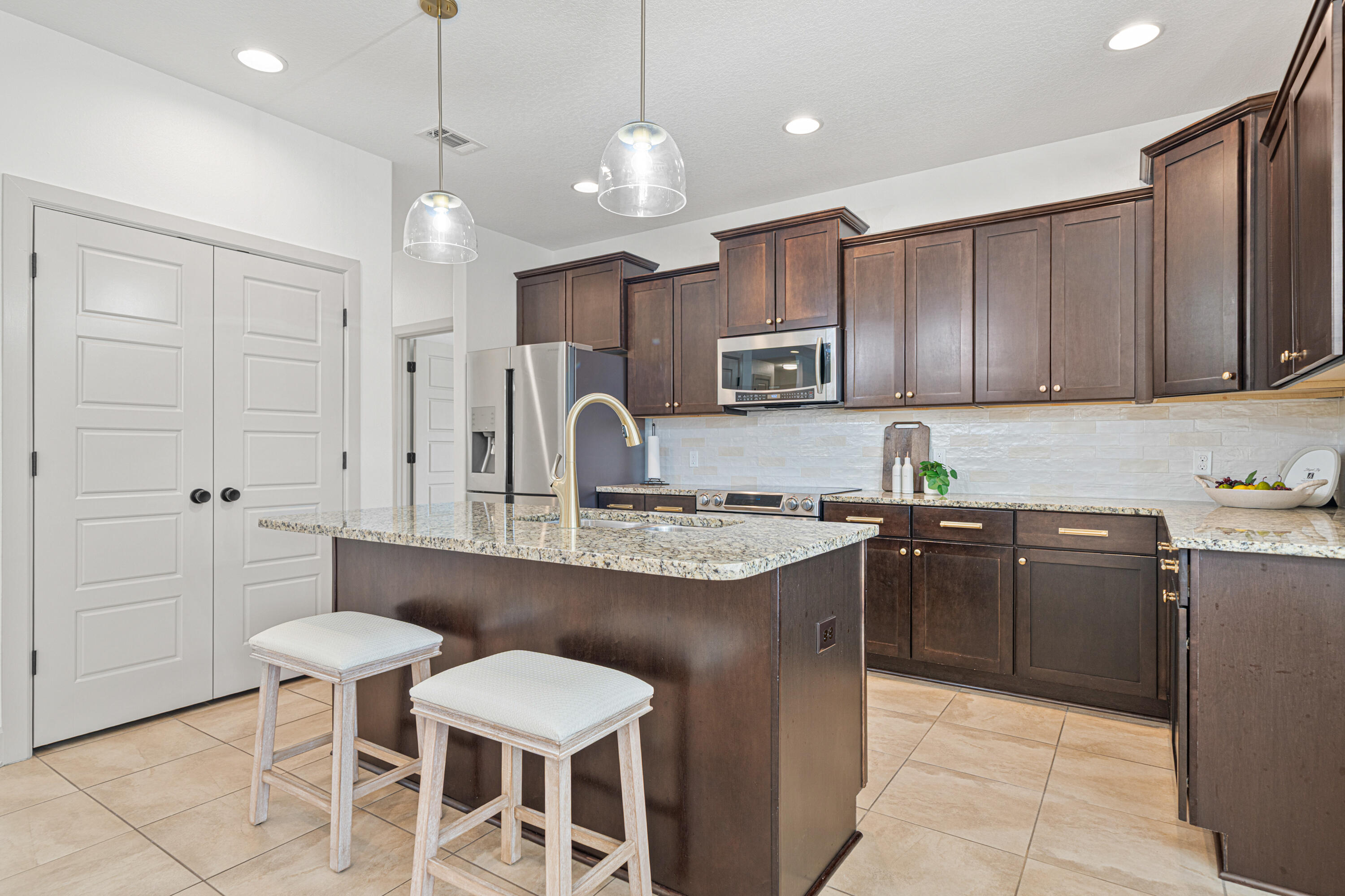 6301 Antigone Circle Crestview, FL 32536 - Photo 24 of 82 a kitchen with stainless steel appliances granite countertop a sink a stove a refrigerator and chairs