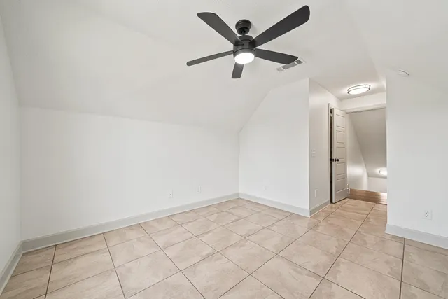 a view of a backyard with table and chairs potted plants and large tree