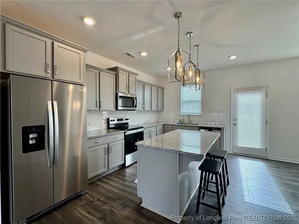 a kitchen with stainless steel appliances a refrigerator sink and microwave
