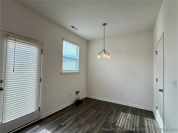 a view of a room with wooden floor and windows