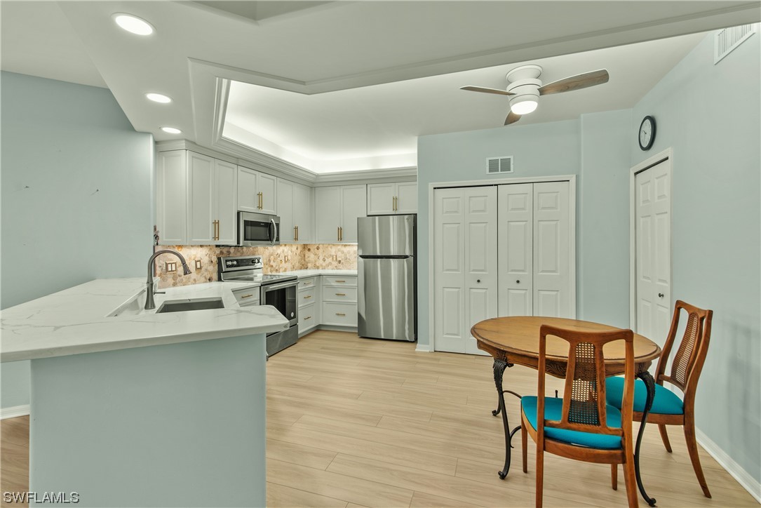 9575 Hemingway Lane, Unit 4410 Fort Myers, FL 33913 - Photo 4 of 23 a living room with a table chairs and a refrigerator