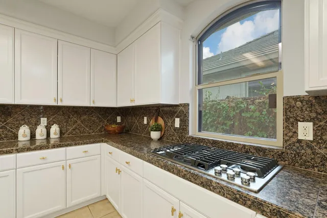 a kitchen with granite countertop kitchen island a sink and a stove