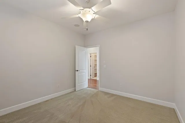 an empty room with a window and a ceiling fan