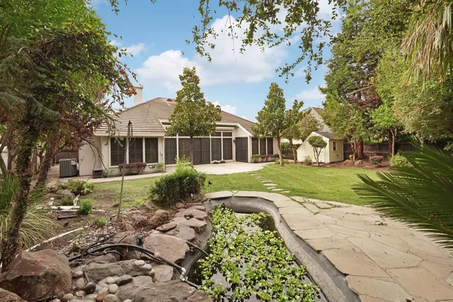 a aerial view of a house with a yard and trees all around