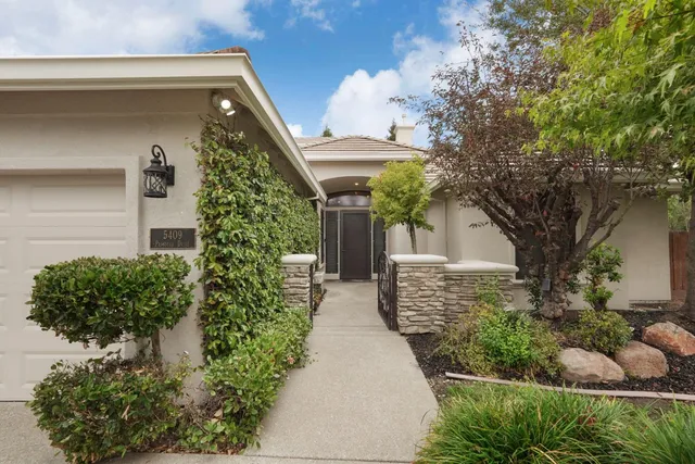 a living room with furniture large windows and wooden floor