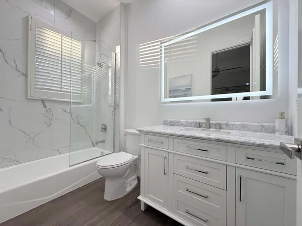 a bathroom with a granite countertop toilet sink and mirror