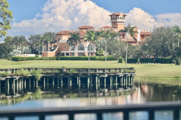 a view of a swimming pool with a garden and lake view