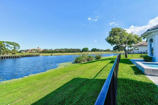 a view of a lake with a big yard and palm trees