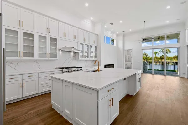 a kitchen that has a lot of white cabinets and wooden floor