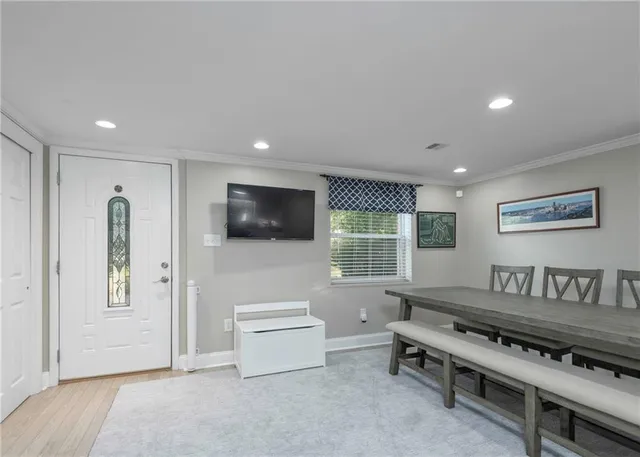 a living room with furniture a flat screen tv and a window