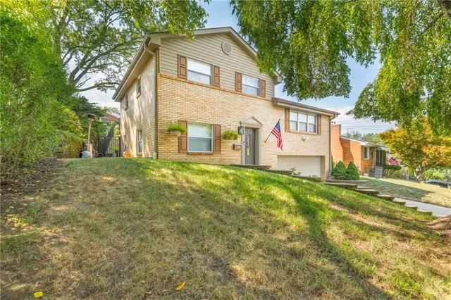 a view of a white house with a big yard and large trees