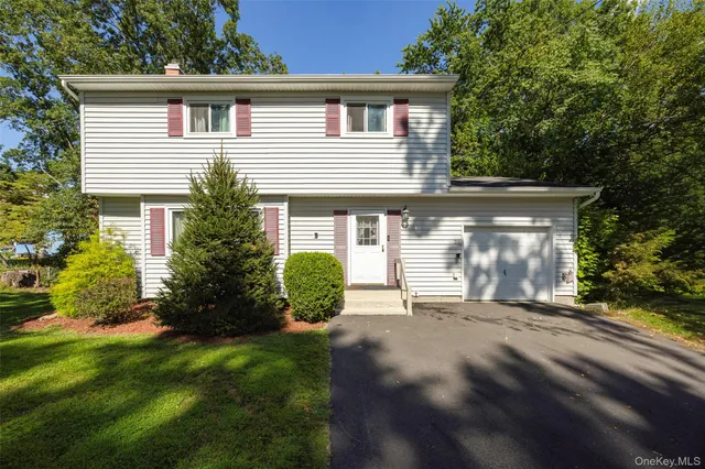 a front view of a house with a garden and yard