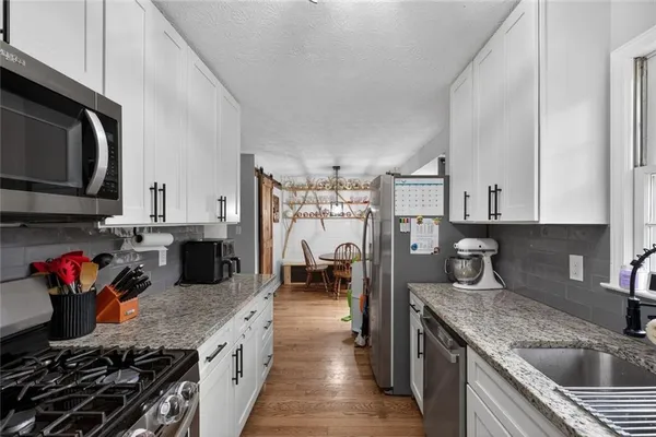 a kitchen with stainless steel appliances granite countertop a sink dishwasher stove top oven and refrigerator