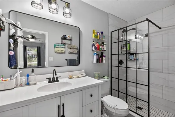 a bathroom with a sink toilet vanity and shower
