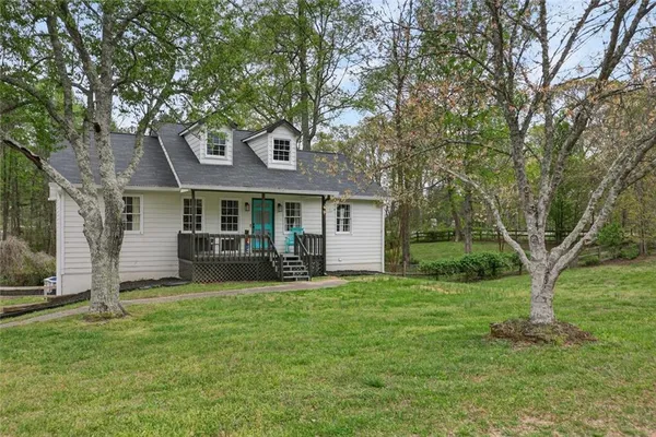 a front view of a house with a garden and trees