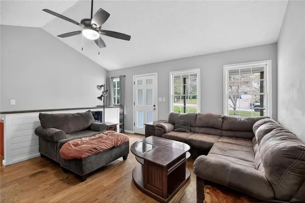 a living room with furniture ceiling fan and a window