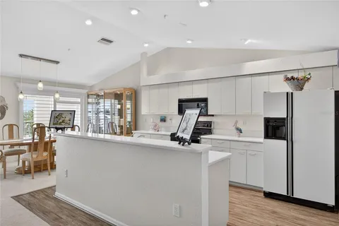 a large kitchen with stainless steel appliances granite countertop a lot of counter space and wooden floors