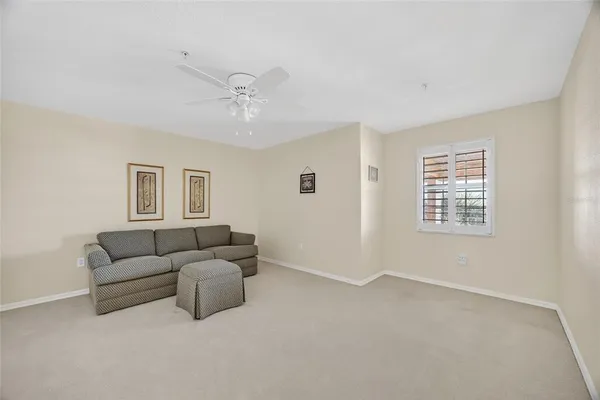 a living room with furniture and a ceiling fan