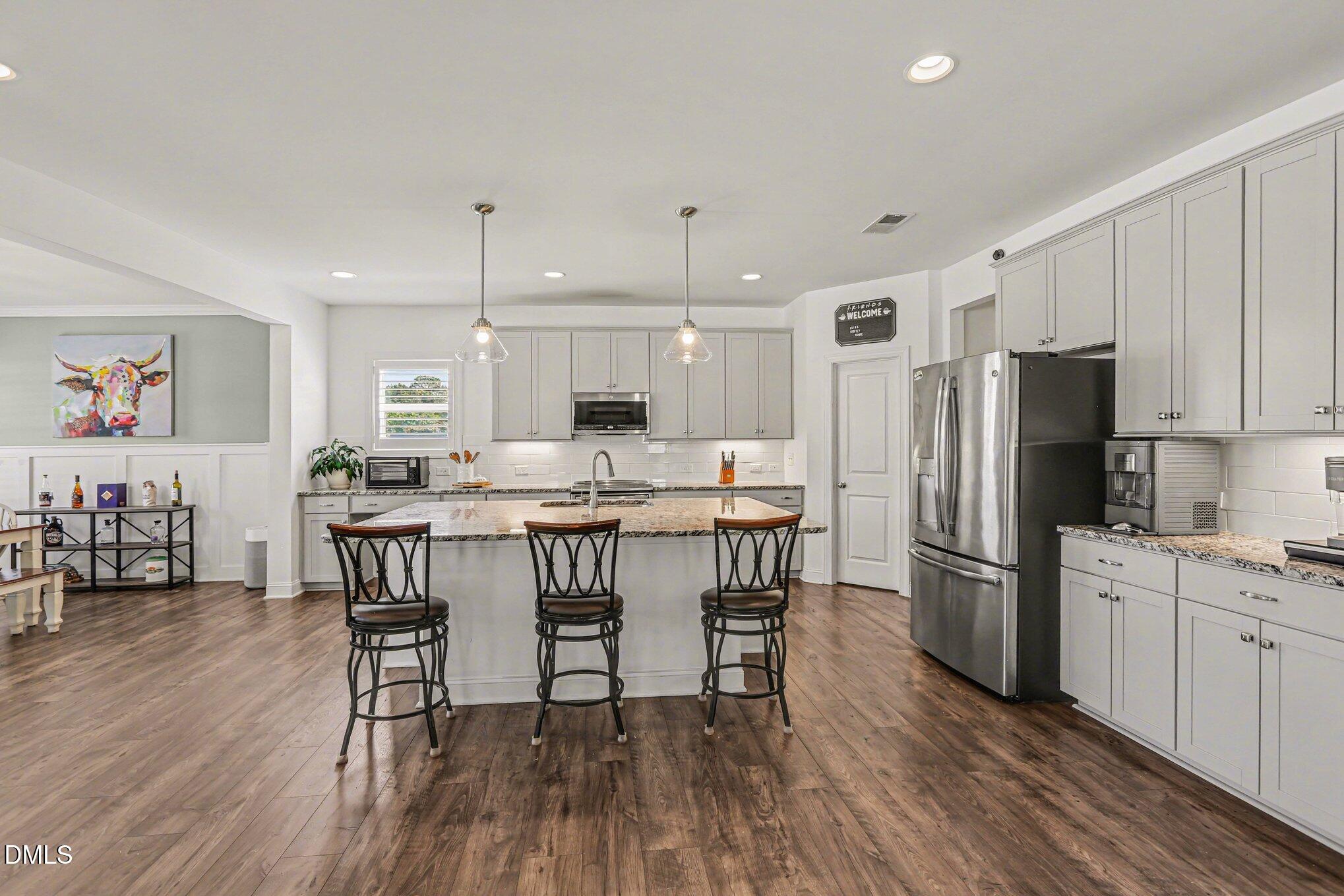 432 Seabring Lane Raleigh, NC 27603 - Photo 9 of 29 a kitchen with stainless steel appliances a dining table chairs refrigerator and sink