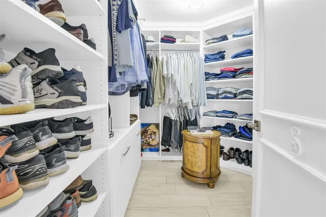 a view of walk in closet with clothes and shoes