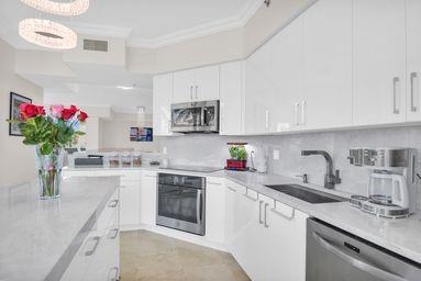 3700 South Ocean Boulevard, Unit 206 Highland Beach, FL 33487 - Photo 9 of 31 a kitchen with white cabinets and a sink