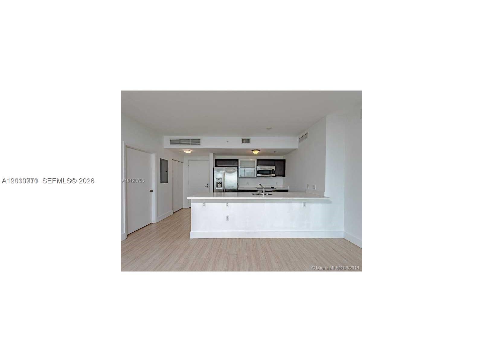 90 Southwest 3rd Street, Unit 2609 Miami, FL 33130 - Photo 2 of 12 a upper view of a kitchen with a sink and a living room area