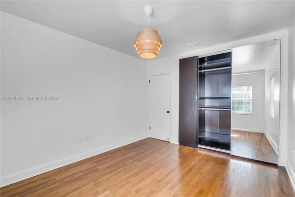 a view of empty room with wooden floor and window