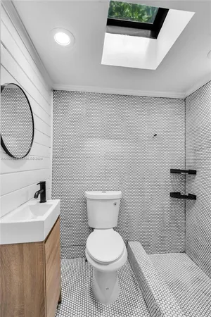 a bathroom with a toilet a sink and mirror