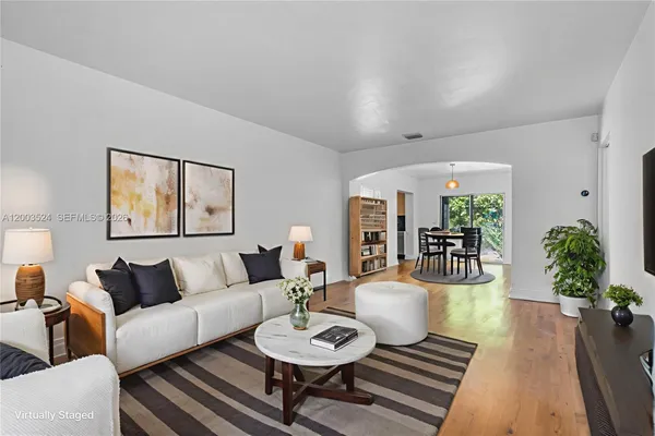 a living room with furniture and wooden floor