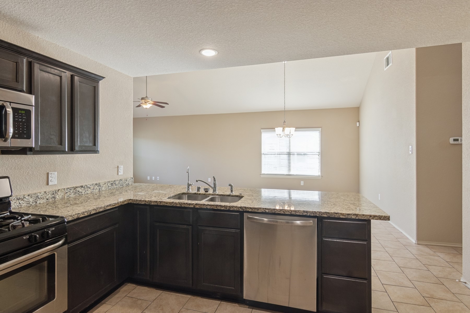 23330 Brat Pass Drive Spring, TX 77373 - Photo 12 of 28 a kitchen with granite countertop a sink and a stove
