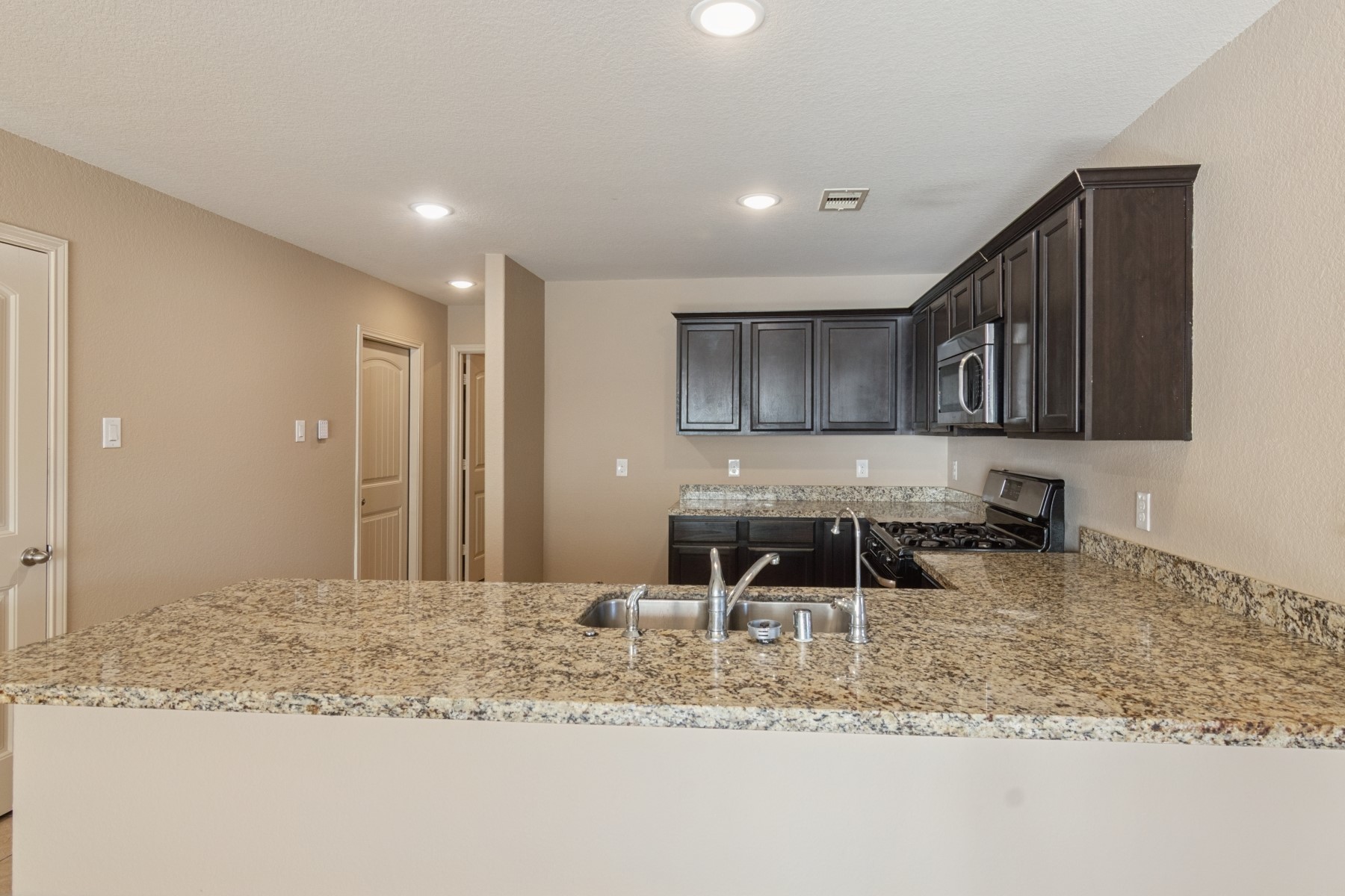 23330 Brat Pass Drive Spring, TX 77373 - Photo 10 of 28 a kitchen with a stove a sink and a microwave