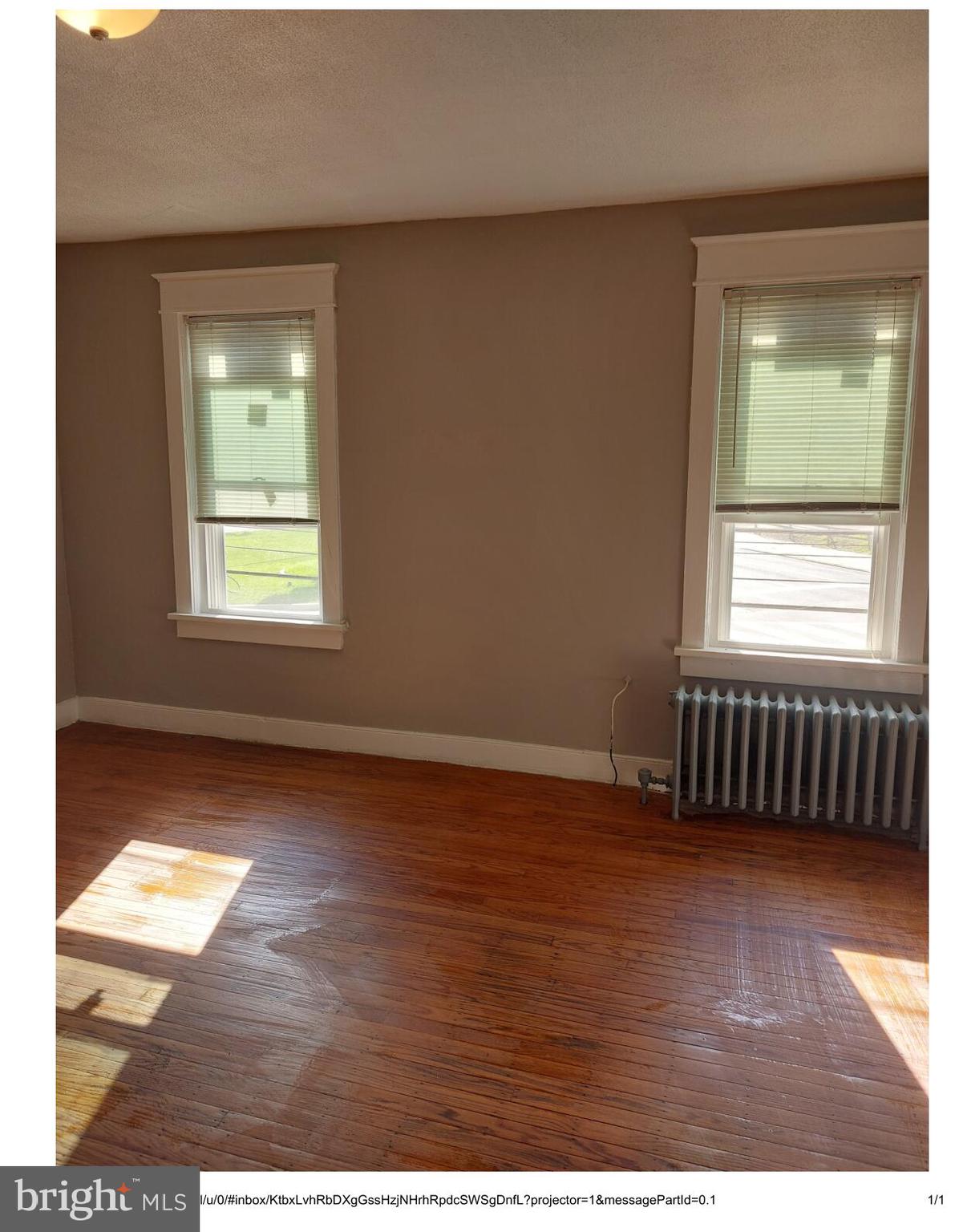 1 Madison Avenue, Unit B Mount Holly, NJ 08060 - Photo 2 of 15 a view of an empty room with wooden floor and a window