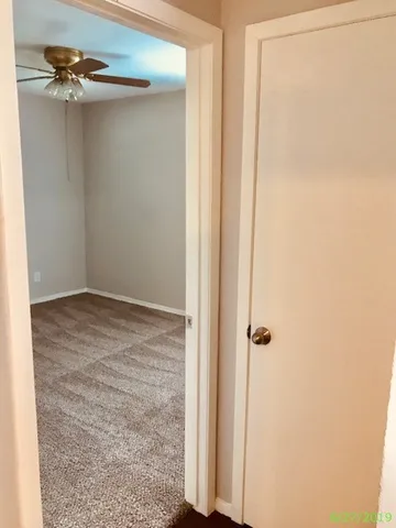 an empty room with a window and a fan