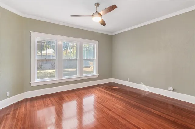 a view of an empty room with wooden floor