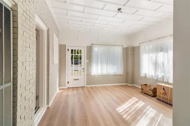 a view of a livingroom with wooden floor and a window