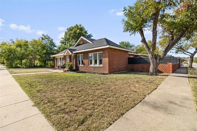 a front view of a house with a yard and potted plants