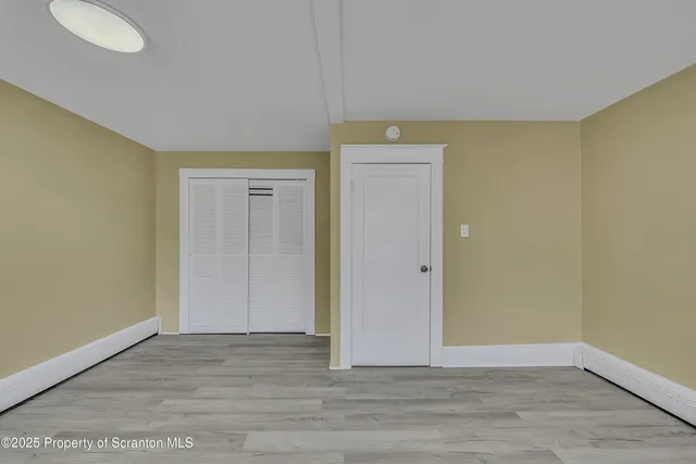 a view of an empty room and wooden floor