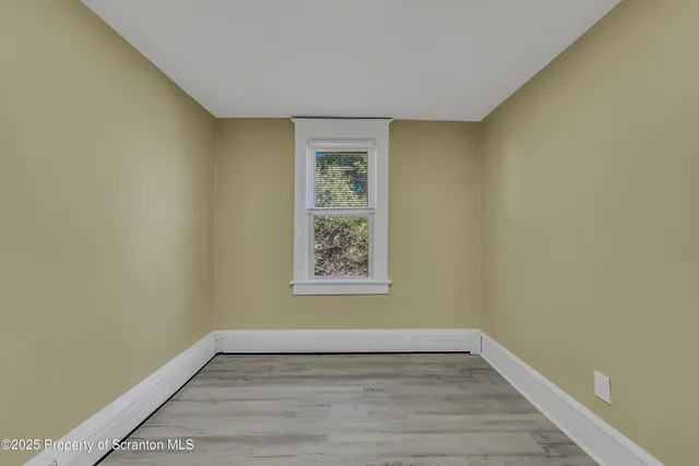 a view of a room with wooden floor and window