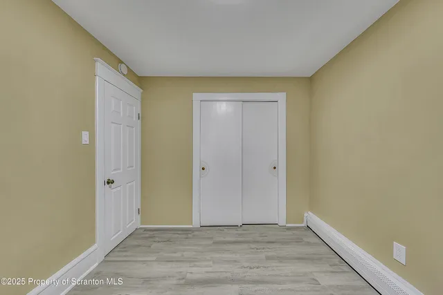 a view of an empty room with wooden floor