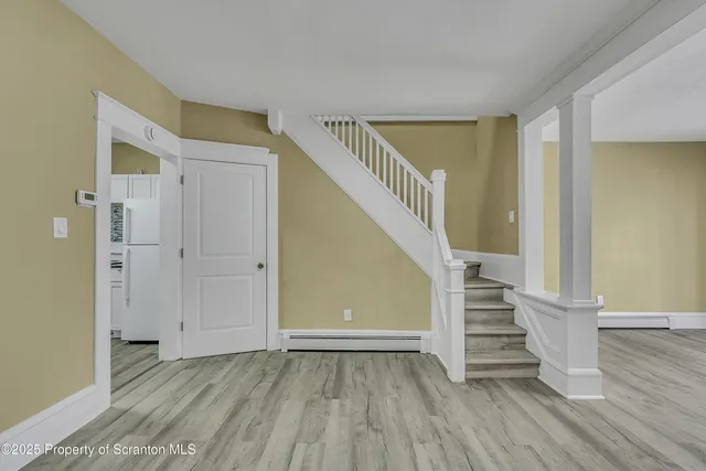 a view of entryway with wooden floor and stairs